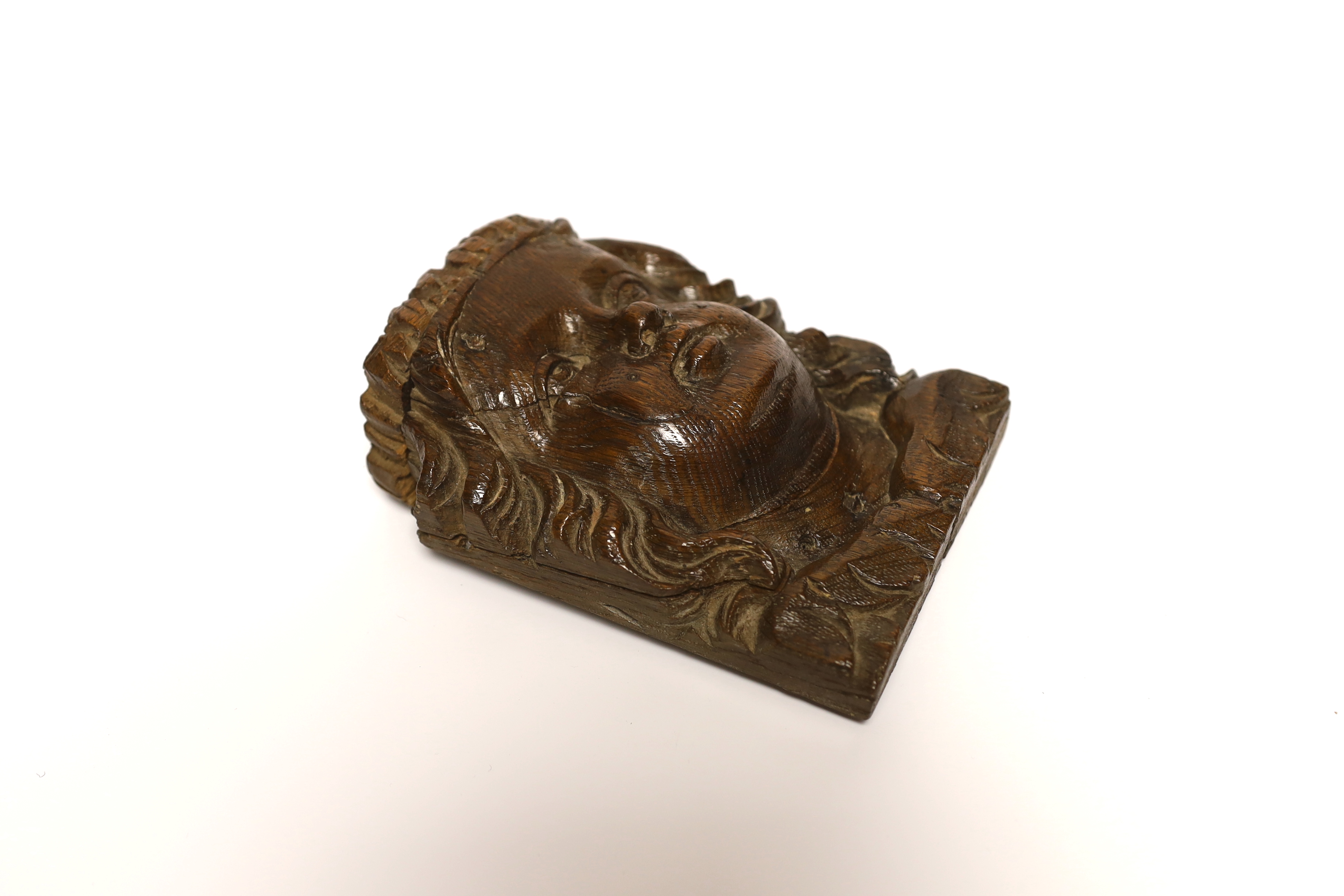 A 17th century carved oak figural terminal, 16cm high